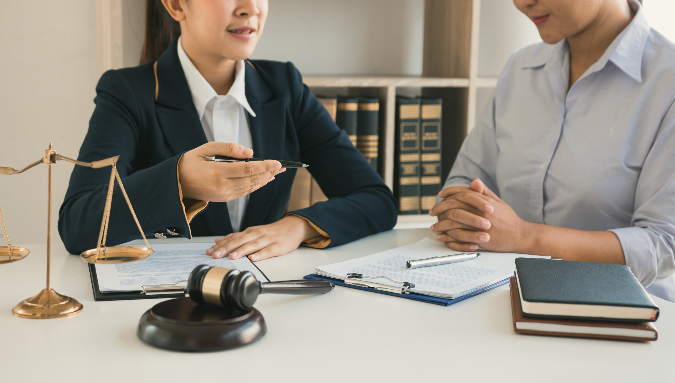 Female lawyer providing legal advices to a woman in an office