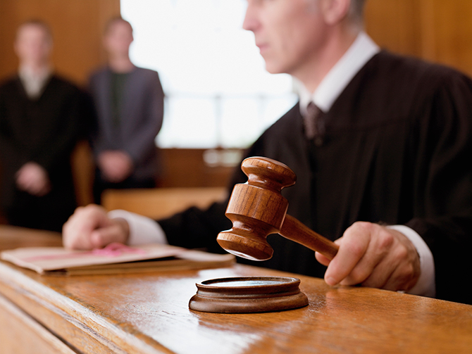 Judge holding gavel in courtroom representing legal judgment process