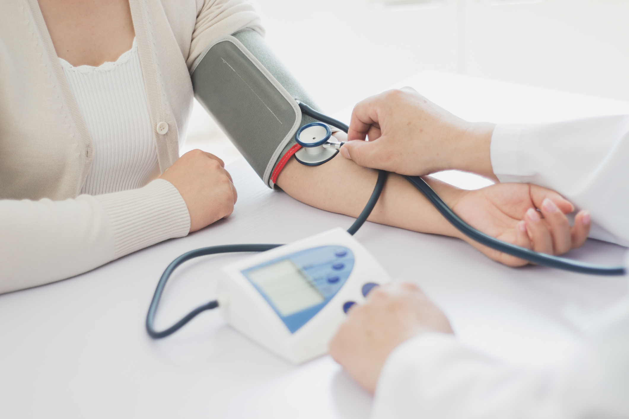 A doctor doing blood pressure measure for a woman