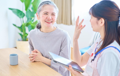 Woman holding a tablet and sharing some health facts to an smiling elderly woman