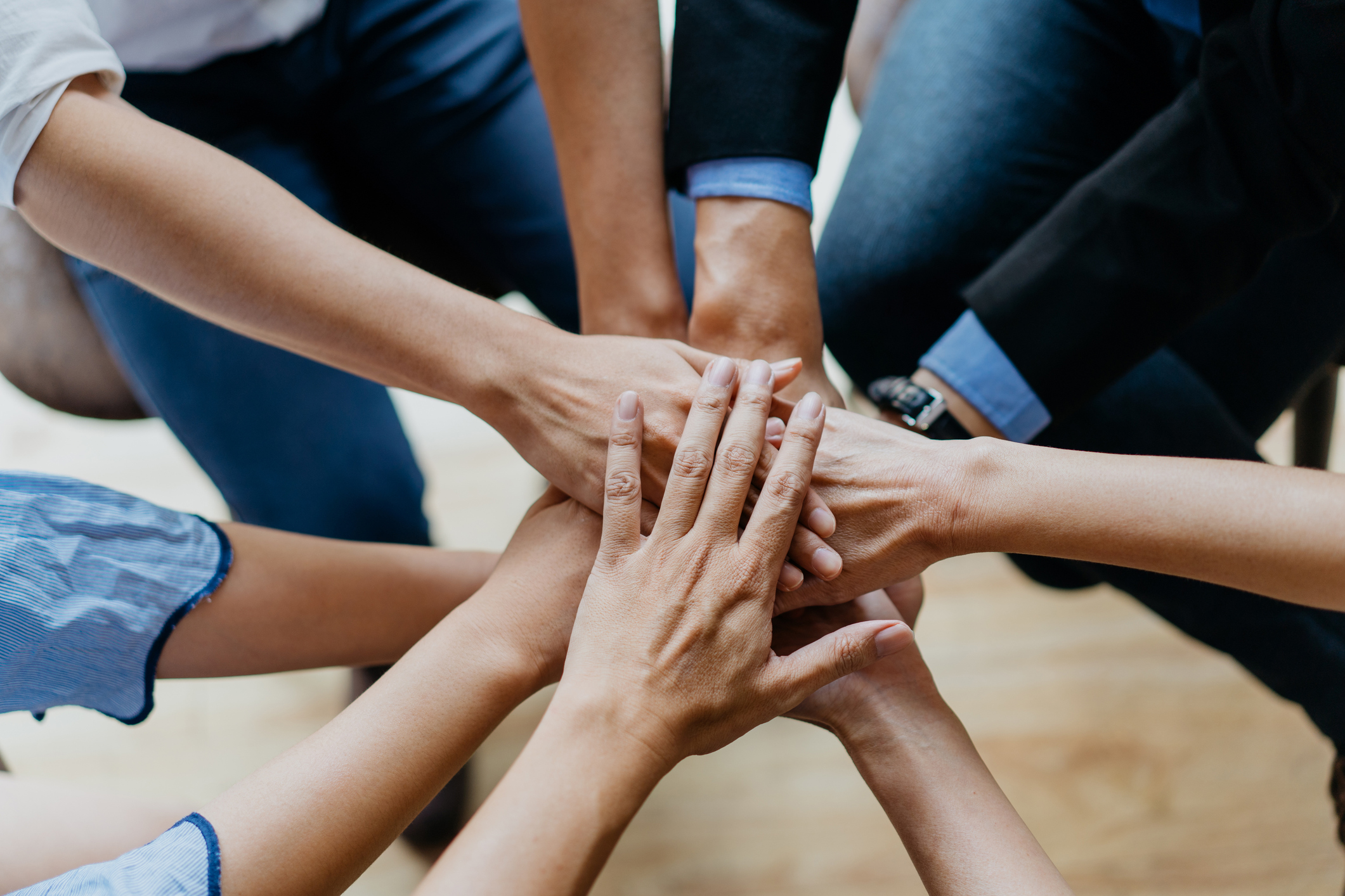 Group of people outdoor stacking hands featuring community engagement
