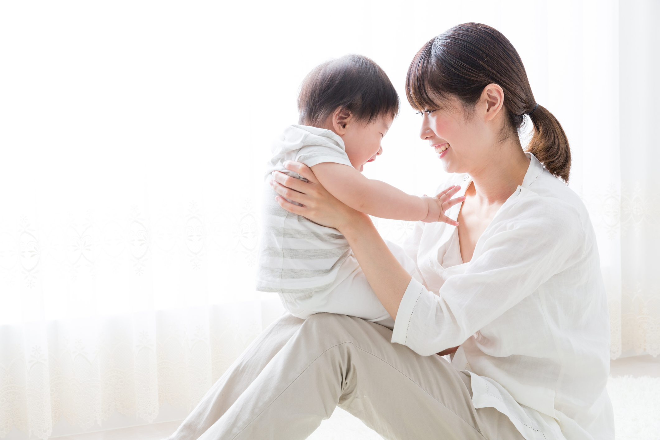 Mother holding a baby and smiling to him