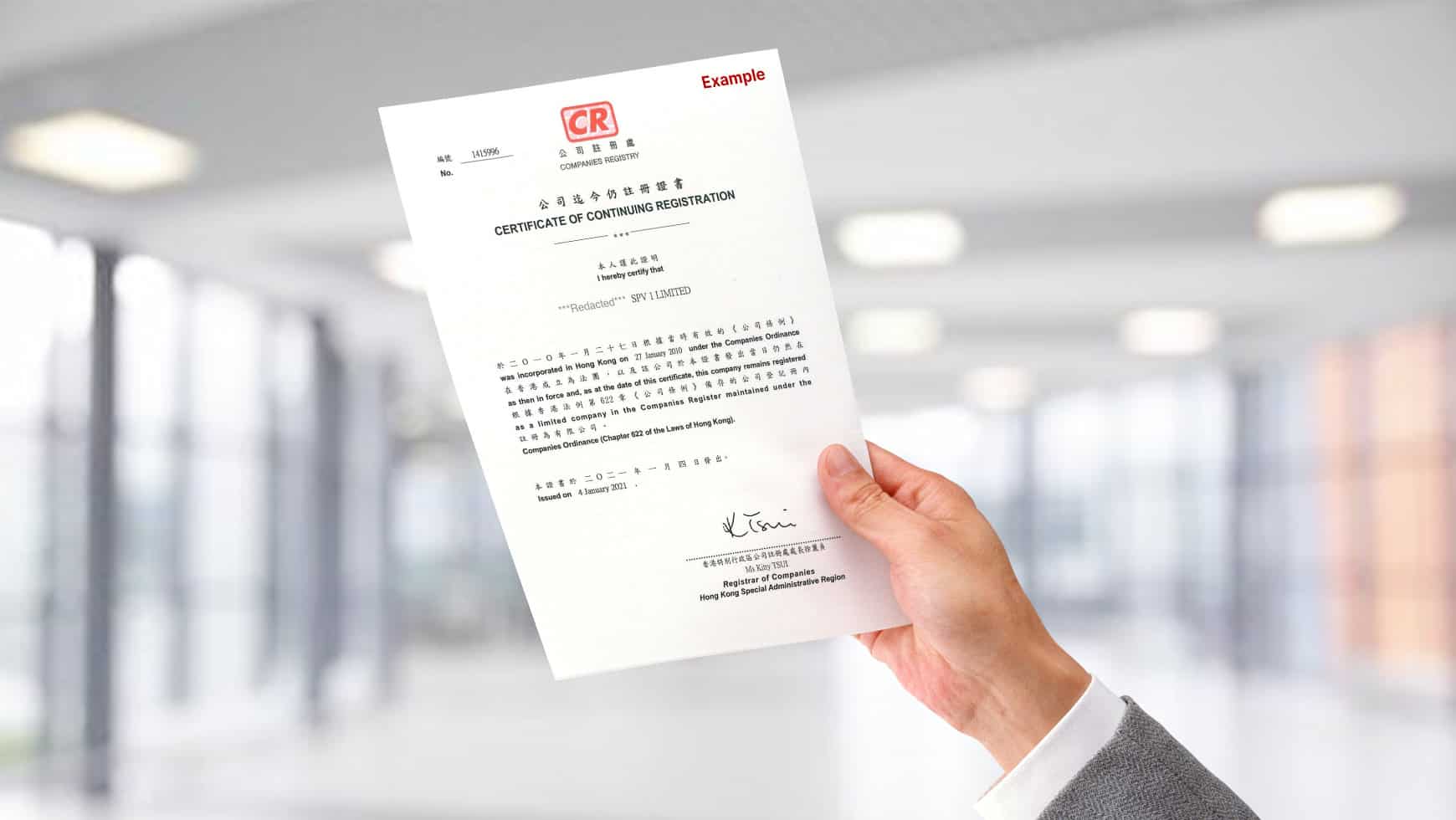 A businessman holding a CR certificate with a office background setting