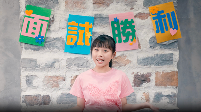 Little girl standing in front of a stone wall with wall rope decoration
