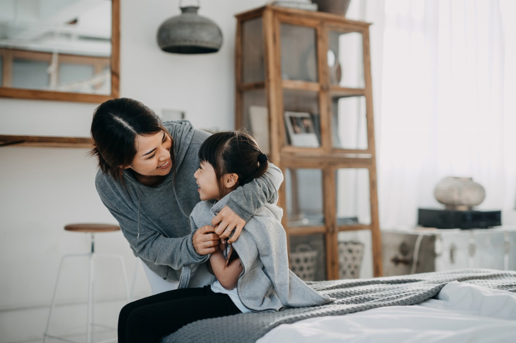 Mother putting a jacket on her daughter
