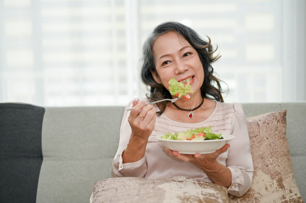 Senior woman eating breakfast with a smile